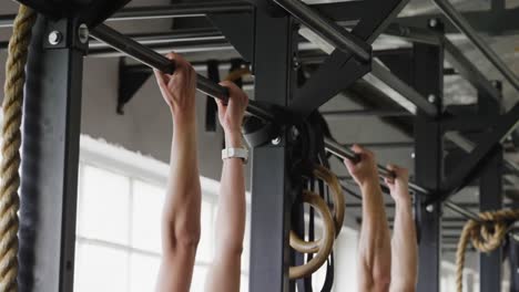 side view athletic caucasian friends doing chin ups