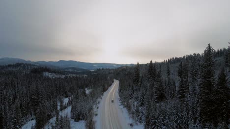 Schneebedeckte-Bergstraße:-Eine-Folgeaufnahme-Eines-Autos,-Das-Entlang-Des-Little-Fort-Highway-24-Fährt,-Umgeben-Von-Waldgebieten-Und-Gipfeln-Im-Abendlicht