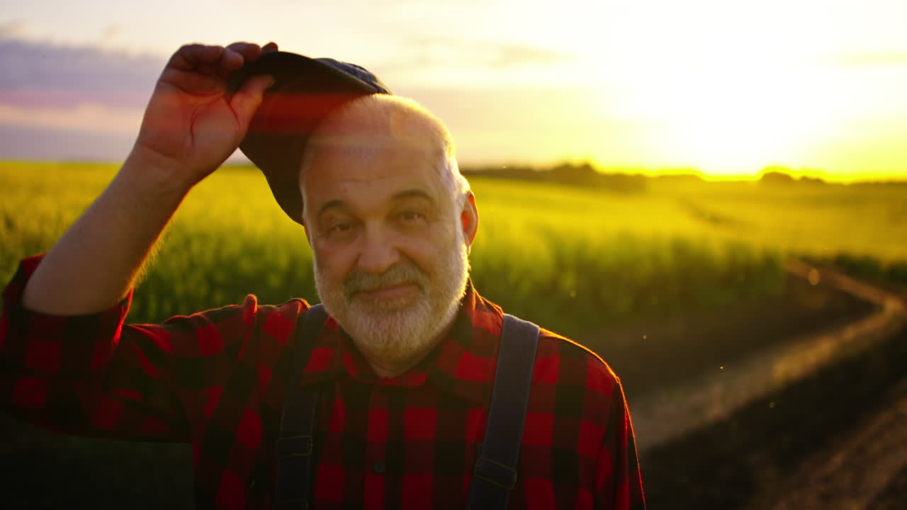 Happy Senior Farmer Smiling in Golden Sunset Field