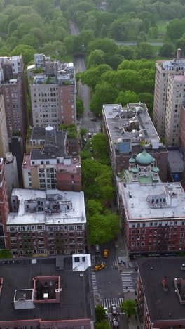 residential area with diverse houses at daytime. beautiful green park and river right behind the quarter. aerial view. vertical video