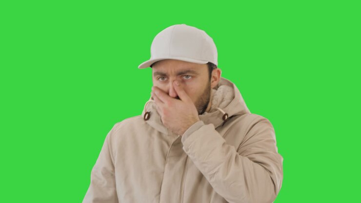 Man in winter outfit walking and coughing on a Green Screen, Chroma Key