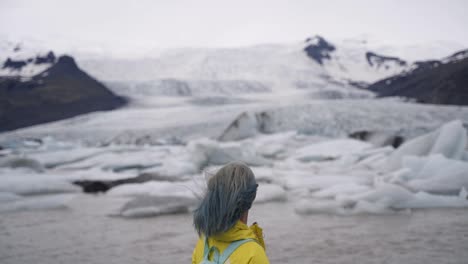 this was taken at a higher frame rate and has been converted to a slow motion video clip.  lady looking at glaciers in iceland.