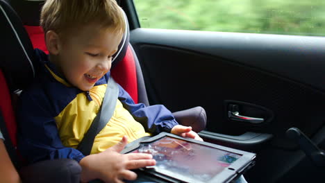 Niño-Pequeño-Jugando-En-Una-Tableta-En-El-Auto