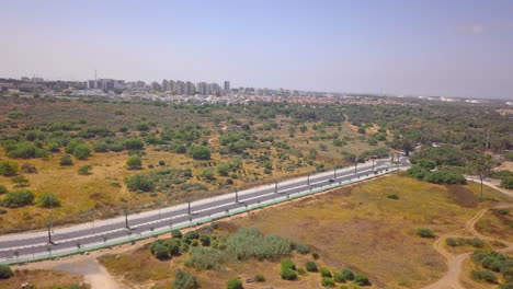 Aerial-shot-of-bike-rider-on-a-lonely-road-in-Southern-Israel-Desert,-dolly-out