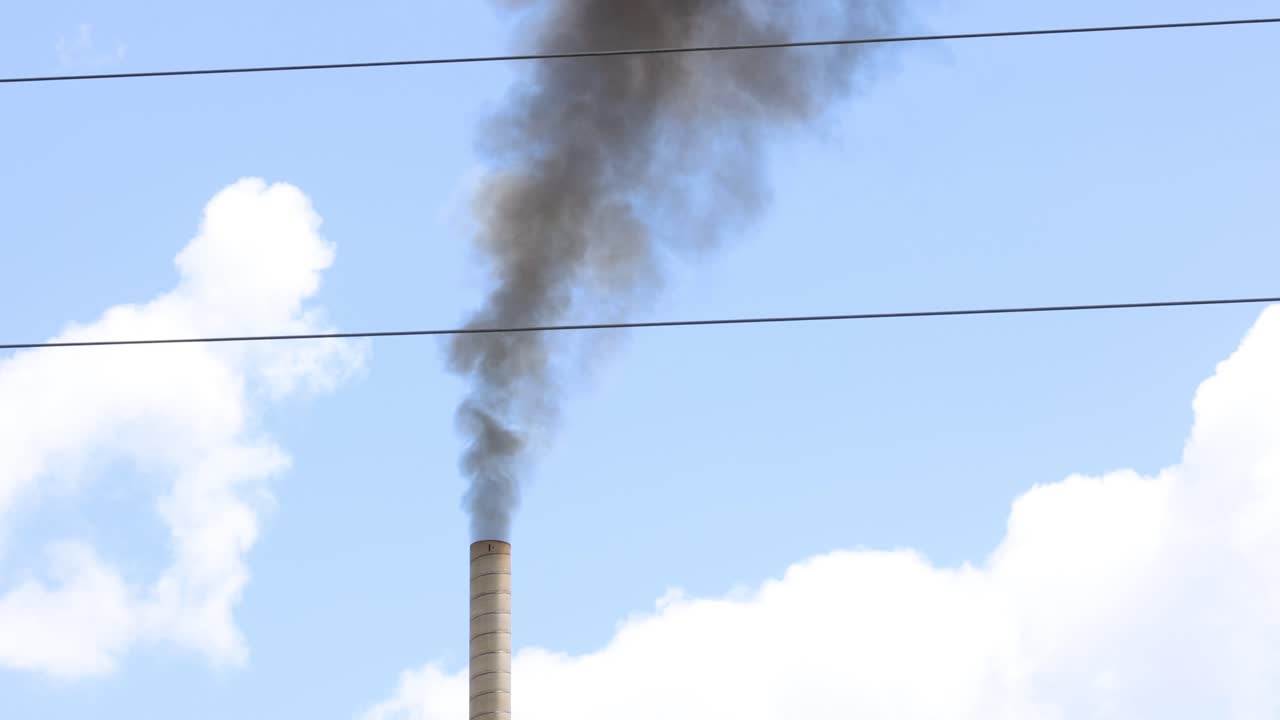 fumo che sorge da un camino contro un cielo blu