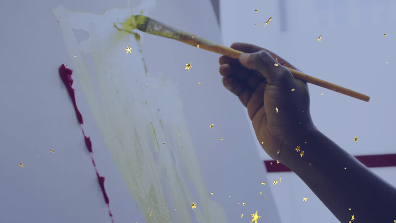 On brush touching canvas, artist layering green marks for watercolor wash as golden stars drifting
