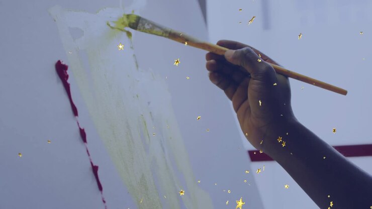 On brush touching canvas, artist layering green marks for watercolor wash as golden stars drifting
