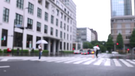 walking people on the street in marunouchi tokyo rainy day