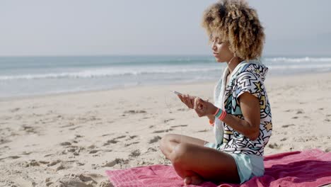 mujer escuchando música en la playa