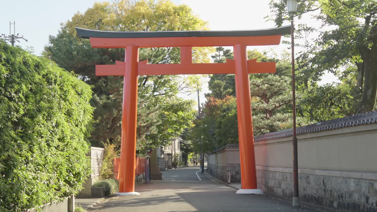 una majestuosa puerta torii se encuentra con gracia en una calle tranquila cerca del santuario shimogamo en kioto, japón, mezclando tradición y modernidad.