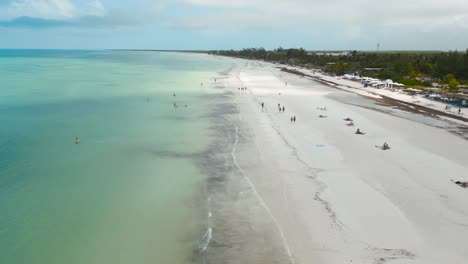 Vista-Aérea-De-Gran-Angular-De-Las-Concurridas-Playas-De-Arena-Blanca-De-La-Isla-Tropical-De-Holbox-En-México-Durante-Un-Día-Soleado-Muy-Caluroso-Filmado-En-4k