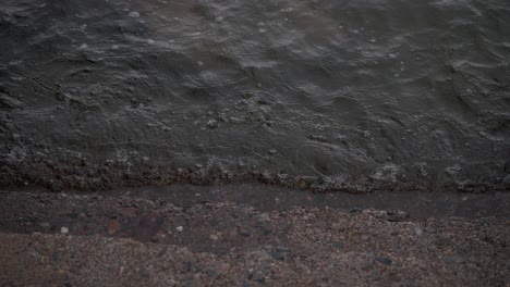 un primer plano del agua del océano mientras fluye suavemente contra escalones de hormigón