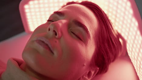 woman relaxing led light on photodynamic procedure close up. client phototherapy