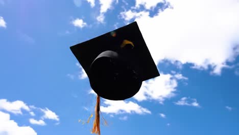 graduates joyfully toss their caps into the air during a graduation ceremony, celebrating their achievements in a scenic outdoor setting with a vibrant blue sky.