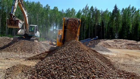 toma en cámara lenta de rocas de transporte de excavadoras y arena en el transportador en el campo minero de arena durante la luz del sol