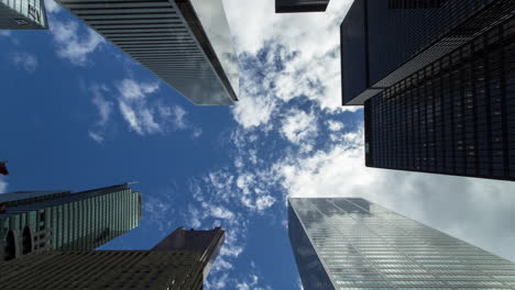 timelapse looking up at the building tops and cloudy sky in the toronto financial district