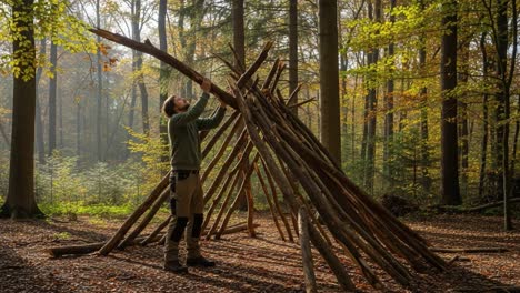 constructing a natural shelter: a craftsman assembles a sturdy bushcraft structure in a serene autumn forest landscape