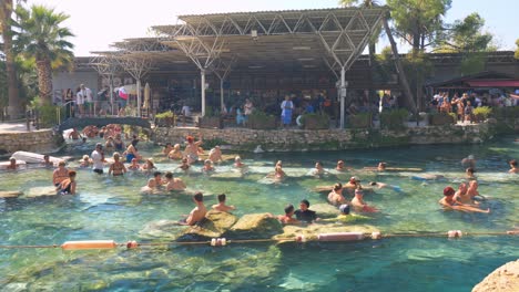 Crowded Hot Springs with People Relaxing and Swimming