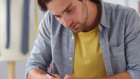 Diseñador-De-Ropa-Masculina-Concentrándose-Mientras-Trabaja-En-Diseños-De-Bocetos-De-Estudio-De-Moda