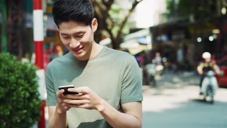 Handheld-view-of-man-with-mobile-phone-walking-in-town