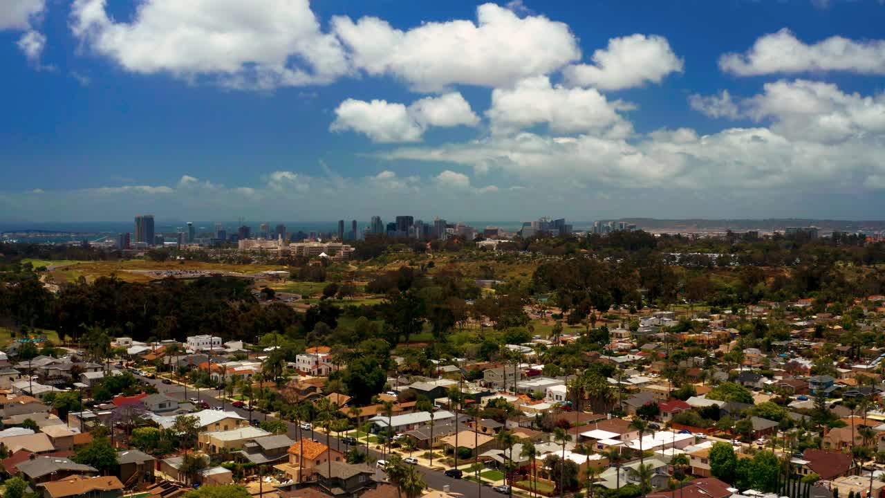 Aerial descending into the North Park neighborhood with San Diego, the bay and Coronado bridge in the distance. Lower of 2