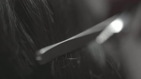 macro shot of hairdresser cutting mans hair with scissors