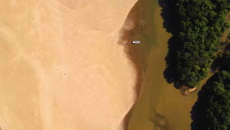 Top-down-drone-shot-flying-over-sand-islands-and-a-small-boat-in-the-Paraná-river-at-the-Apipé-islands-in-Corrientes,-Argentina