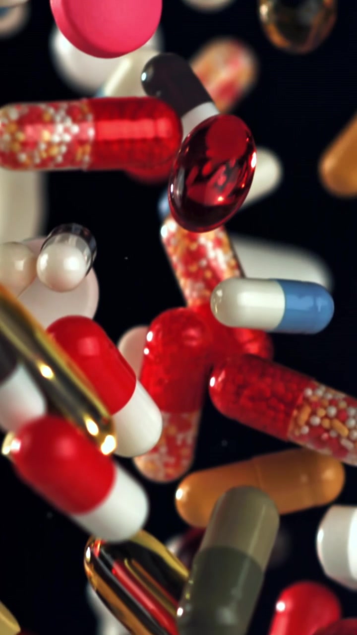 Assortimento di pillole e capsule colorate che cadono al rallentatore