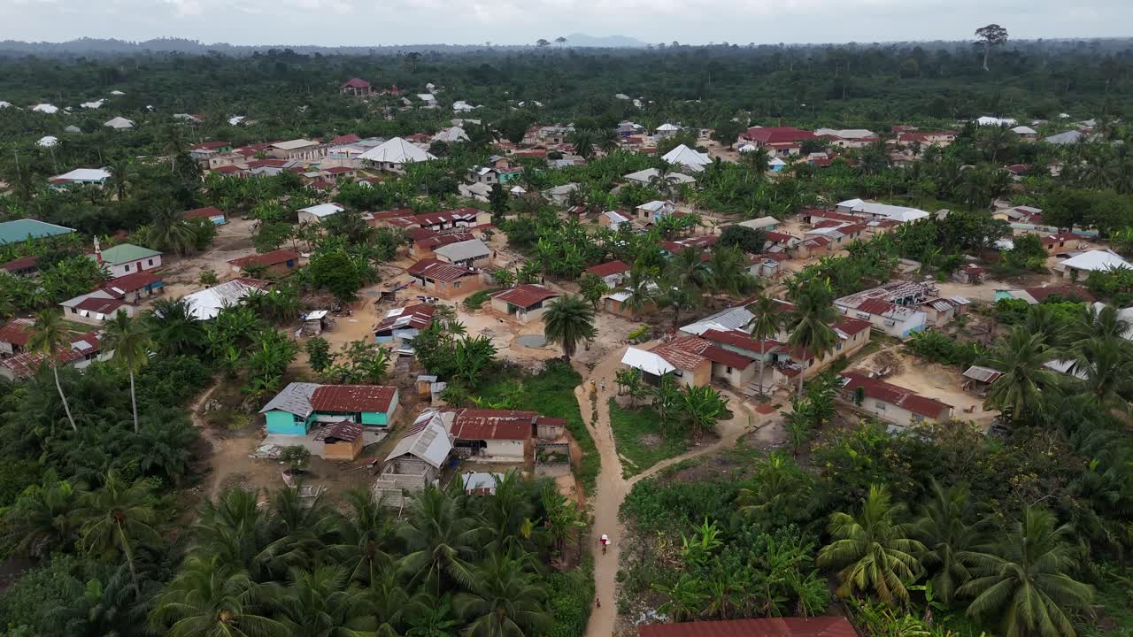 Droneoptagelse af landbebyggelsen Fumso, Ghana. Viser traditionelle hustage omgivet af frodig tropisk vegetation og palmetræer. Vestafrikansk landsbysceneri.