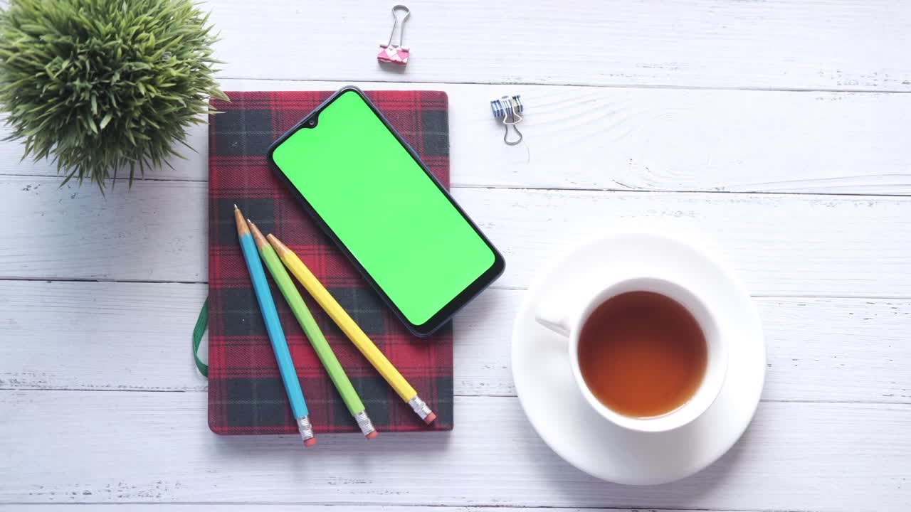 top view of smart phone and notepad on table