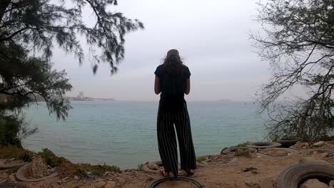 vista posterior de una turista frente al océano en la costa atlántica de senegal