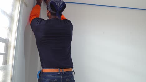 close up of man putting on painter's tape