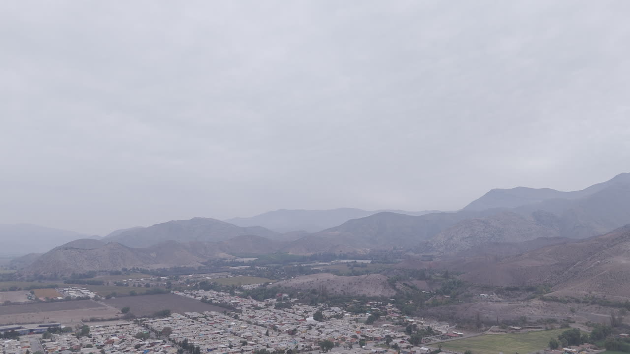 Wide drone shot around the town of Vicuña near Coquimbo in Chile South America on a grey day with mountains in the background LOG