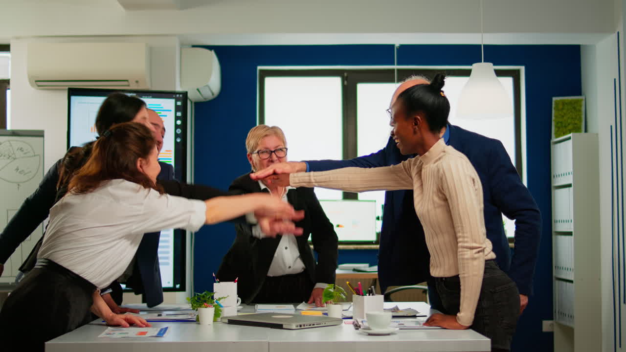 Overjoyed multiethnic company team throwing up hands celebrating successful