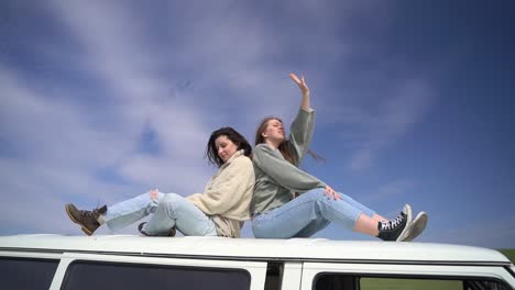 two young girls on the roof of a caravan in the middle of the countryside