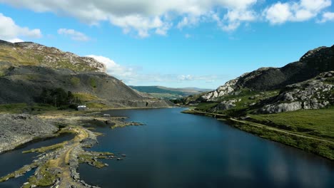 Hermosa-Vista-Aérea-Sobre-Un-Lago-Que-Se-Encuentra-Con-Las-Majestuosas-Montañas-De-Gales