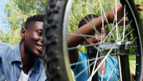 Man-repairing-a-bike-with-his-son