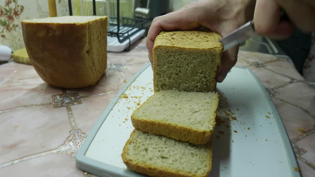 Freshly baked bread is sliced and displayed, showcasing its soft interior. A simple, everyday moment of food preparation
