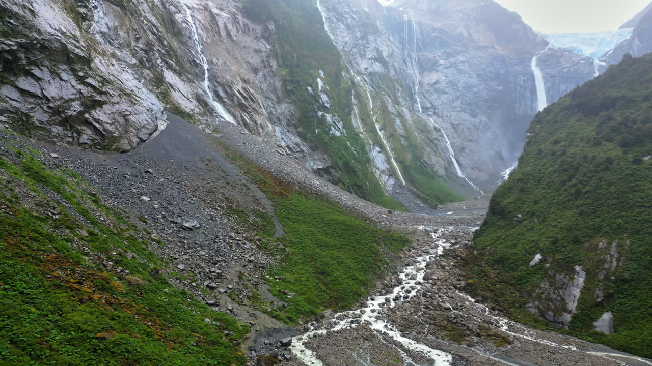 Aerial drone view of a glacier melt river with intricate channels flowing into a turquoise lake