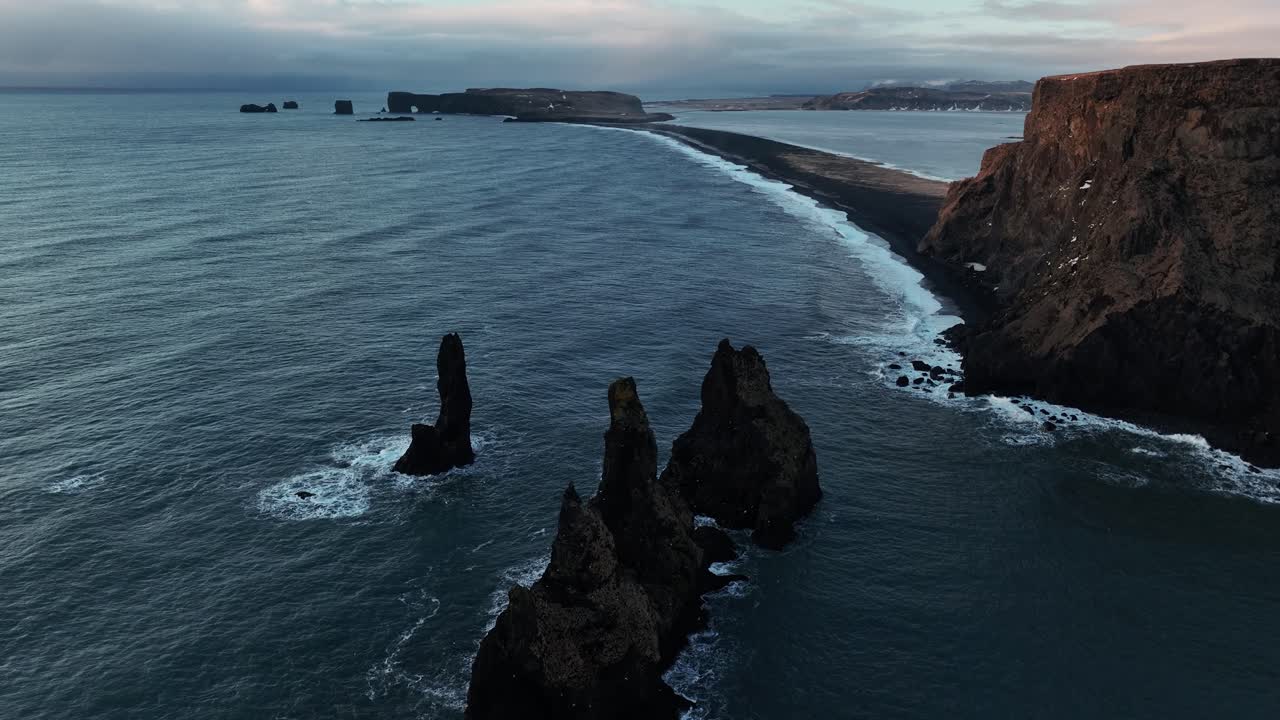 Basalt Rock Formations Of Reynisdrangar And Reynisfjara Beach Near Vik In South Iceland. orbiting drone shot