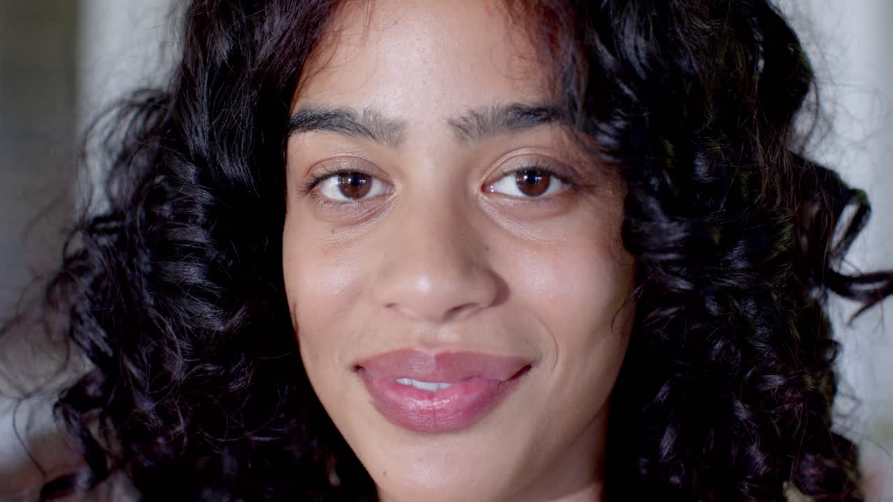 African American female smiling gradually at close-up, responding to camera, showing teeth and eyes