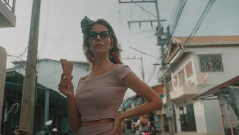 stylish woman eating ice cream on a street
