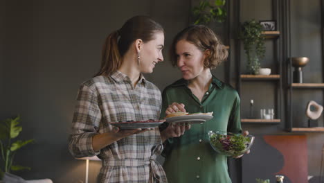 Zwei-Glückliche-Frauen,-Die-Zu-Hause-über-Essen-Reden-Und-Zusammen-Lachen