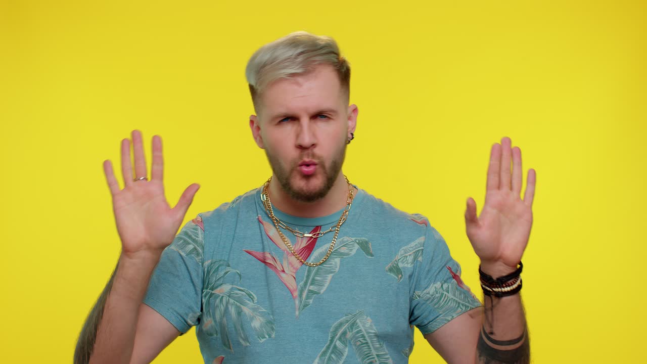 트렌디하고 쾌활한 남자가 춤을 추고 리에 따라 움직이고, 손을 들고, 댄스 몸짓을 합니다.