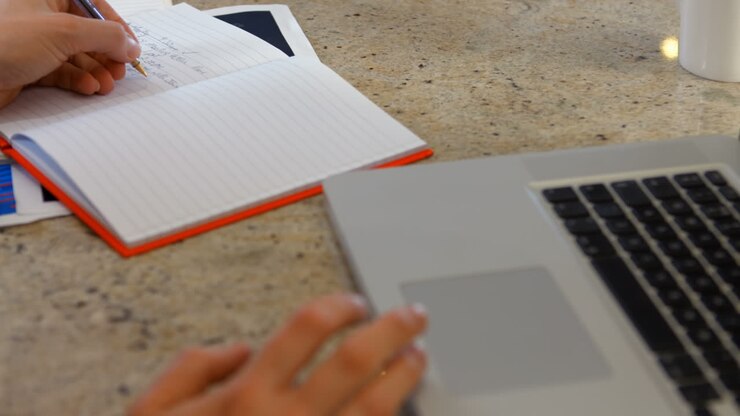 Woman using notebook and laptop