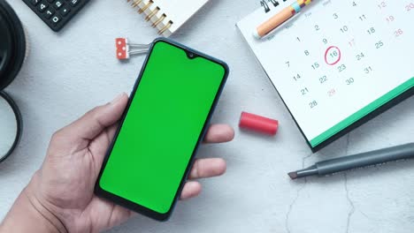 vista superior de la mano del hombre usando teléfono inteligente con calendario y en la mesa