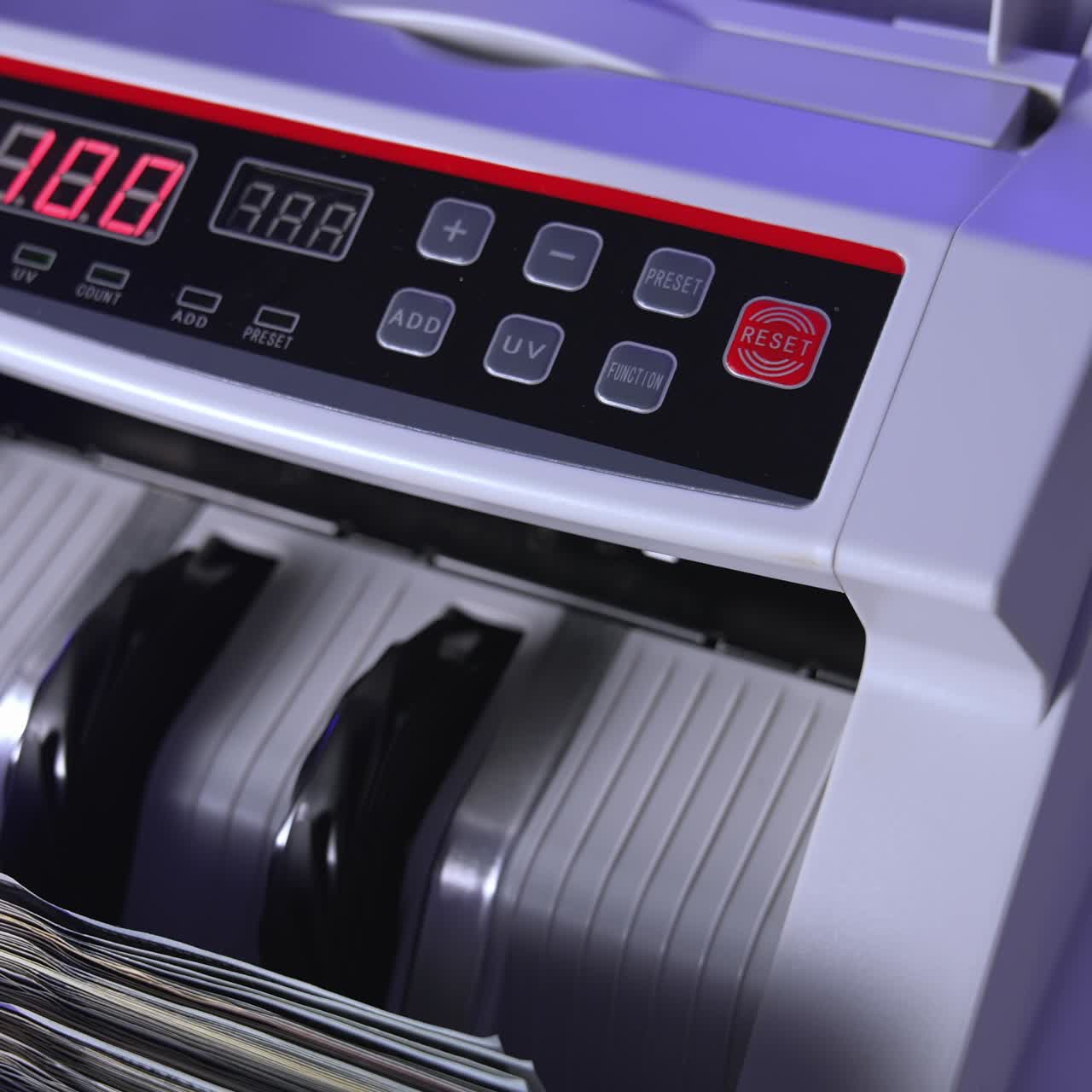 100 US dollar in money counting machine in action, close up