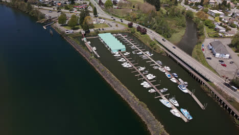 harbor quay and boats docked at marina docks at port alberni, british columbia canada, aerial descending view