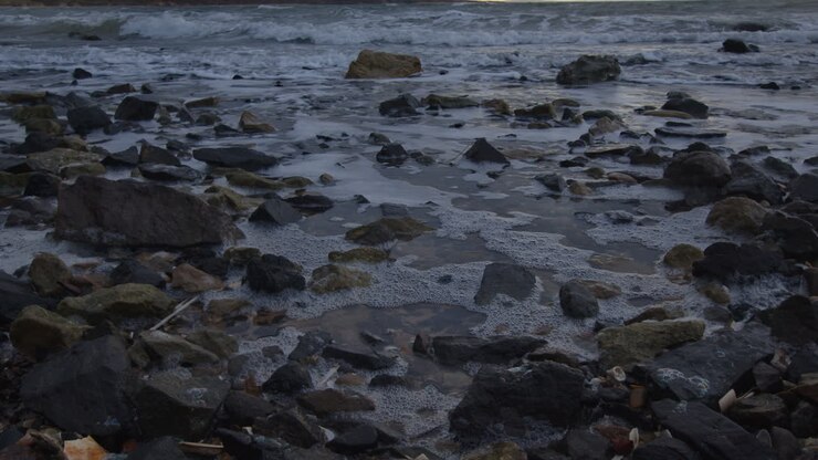 Onde che lambiscono una spiaggia con l'alta marea sulla costa all'inizio di una tempesta sulla costa orientale della Scozia a febbraio 2024. Angolo 3.