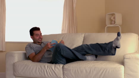 Attractive-man-jumping-on-couch-with-book